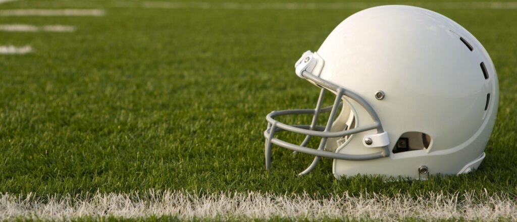 American,Football,Helmet,On,The,Field,With,Room,For,Copy