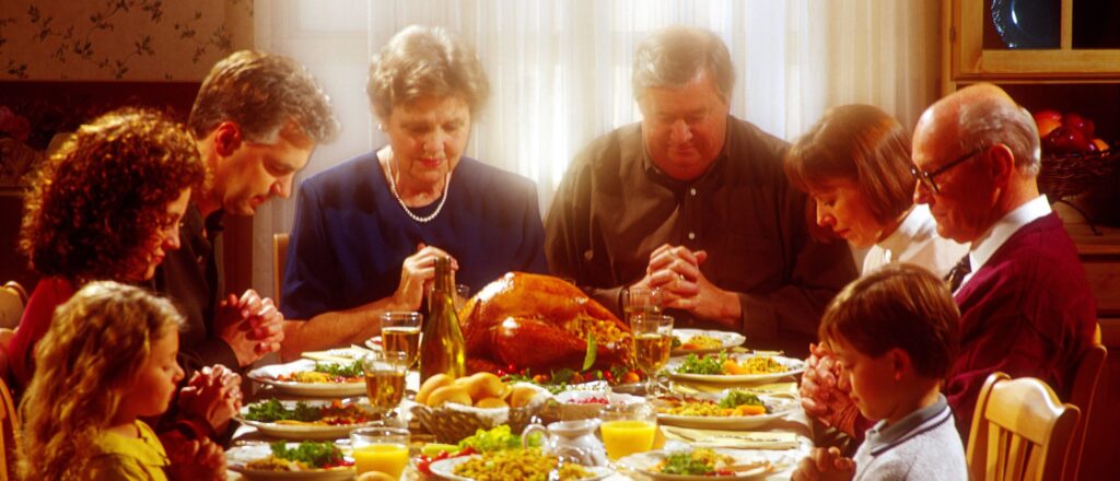 Family praying together over Thanksgiving dinner