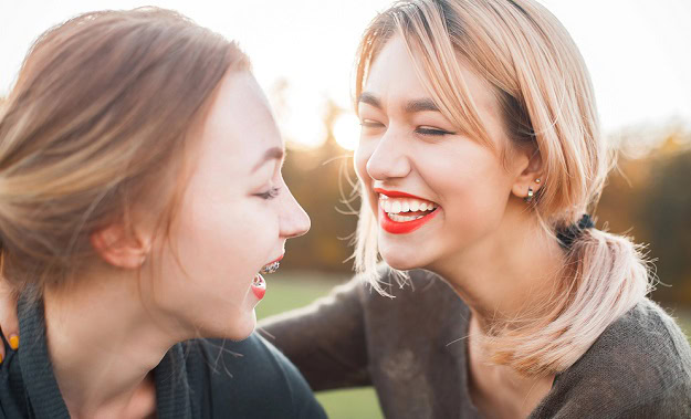 Hilarious Humor for a Great End to the Summer Two women laughing outdoors in the sun.