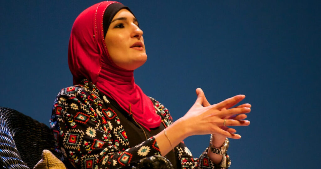 DSA Activist Linda Sarsour Wants to Replace the Declaration of Independence With Something That Reflects the Values of the Radical Left (VIDEO) A woman in a red hijab passionately speaks during a conference, gesturing with her hands while seated on a wicker chair.