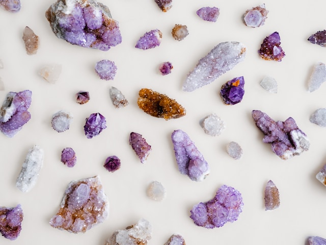 Crystals, Belief, And What The Evidence Actually Shows Assorted quartz and amethyst crystals arranged on a pale linen surface