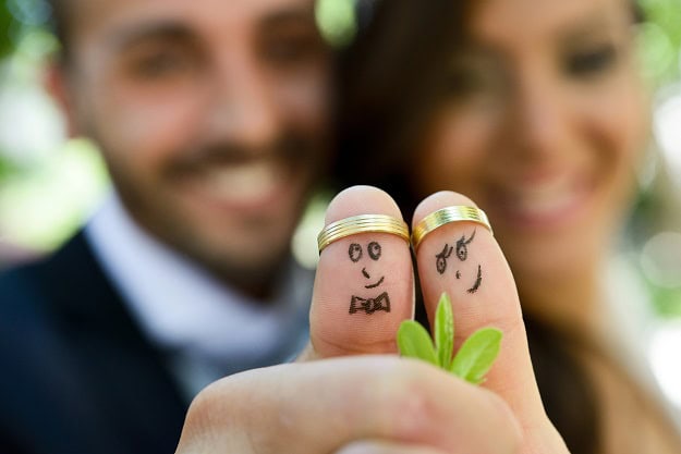 Hilarious Humor for a Love That Lasts A newly wed couple with their thumbs up with smiling faces drawn on them and the wedding rings as thumb crowns.