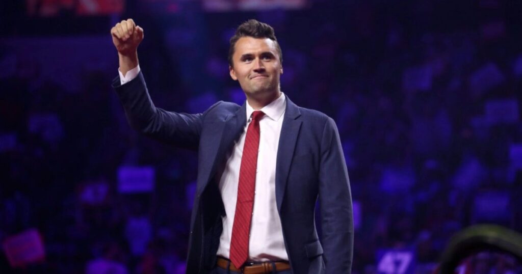 Students at Georgetown Planning Charlie Kirk ‘Lookalike Contest’ on Anniversary of His Assassination * The Gateway Pundit * by Mike LaChance Man in a suit raising his fist in a crowd, expressing confidence and enthusiasm at a public event.