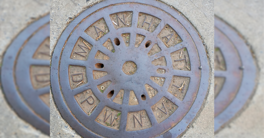 Two Men Arrested After Being Spotted Emerging from Manhole Near NYC Hotel Where Netanyahu Regularly Stays for UN General Assembly Manhole cover featuring the word